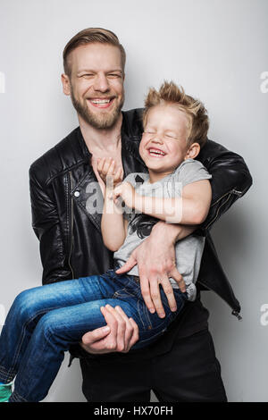 Junger Vater und Sohn gemeinsam lachen. Vatertag.  Studio-Porträt auf weißem Hintergrund Stockfoto