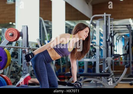 Sportliche Mädchen mit Hanteln in Händen Übungen in spo Stockfoto