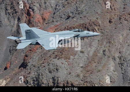 Vereinigte Staaten Marine F/A-18 Super Hornet auf niedrigem Niveau durch eine Wüste Schlucht fliegen. Stockfoto