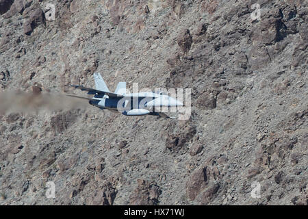 Vereinigte Staaten Marine F/A-18E Super Hornet auf niedrigem Niveau durch eine Wüste Schlucht fliegen. Stockfoto