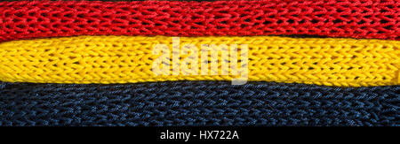 Gestrickte Fragmente der Flagge Farben-rot, blau, gelb Stockfoto
