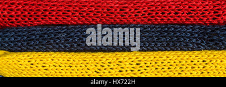 Gestrickte Fragmente der Flagge Farben-rot, blau, gelb Stockfoto