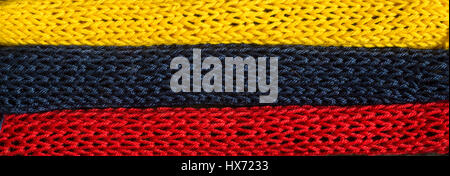 Gestrickte Fragmente der Flagge Farben-rot, blau, gelb Stockfoto