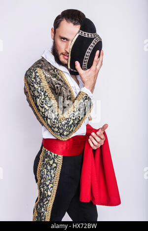 Mann verkleidet als Matador auf weißem Hintergrund. Studio-Porträt Stockfoto