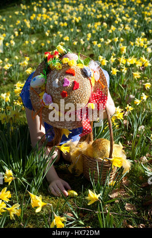 Mädchen mit Ostern Motorhaube auf ein Easter Egg hunt in Lancashire, UK Stockfoto