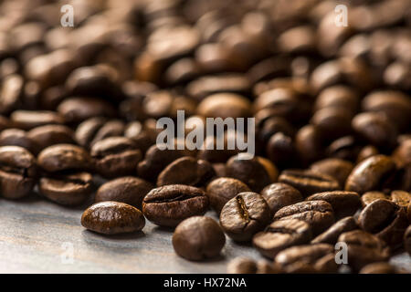 Geröstete Kaffeebohnen auf lackierten Holzplatte Stockfoto