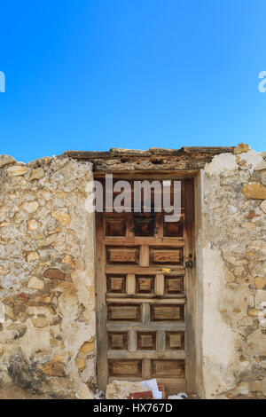 Verwitterte Holztür auf ein verfallenes Haus gegen blauen Himmel in Südspanien, mediterran Stockfoto