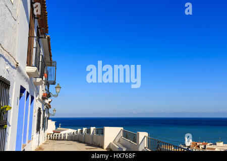 Blick entlang eines traditionellen weiß getünchten spanischen Dorfhauses auf das Mittelmeer in der Altstadt von Sella, Costa Blanca, Spanien Stockfoto