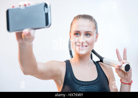 lächelnde junge Frau mit Tennisschläger machen Selfie auf smartphone Stockfoto
