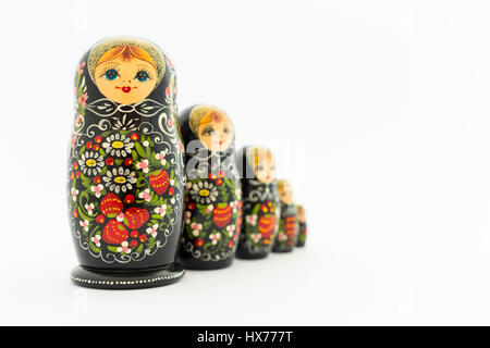 Schöne schwarze russische Verschachtelung Puppen (Matroschka Puppen) mit weißen, grünen und roten Anstrich vor weißem Hintergrund Stockfoto