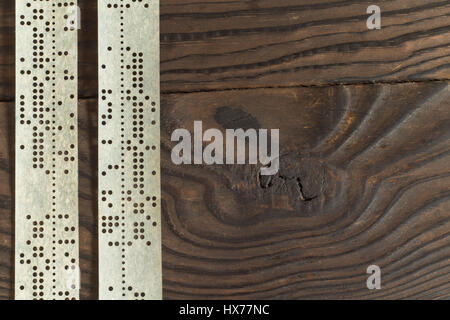 Streifen von alten gestanzt Klebeband auf dunklen Holzoberfläche Stockfoto