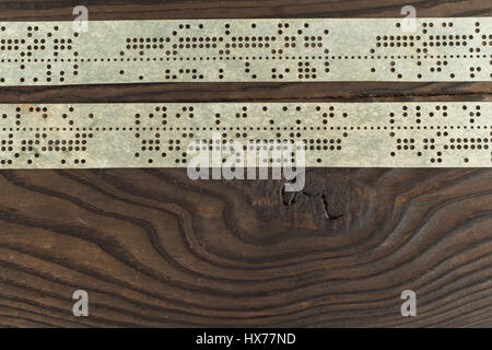 Streifen von alten gestanzt Klebeband auf dunklen Holzoberfläche Stockfoto