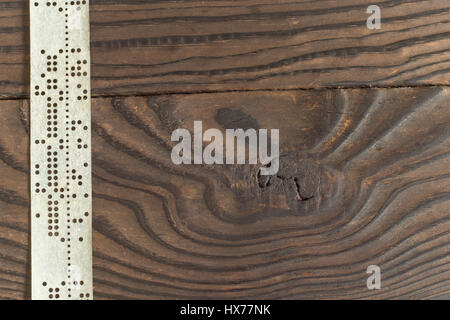 Streifen von alten gestanzt Klebeband auf dunklen Holzoberfläche Stockfoto