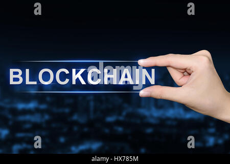 Hand drücken Blockchain Taste auf blauen Hintergrund jedoch unscharf Stockfoto