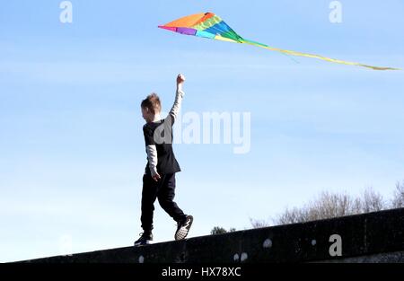 Anmerkung des Herausgebers: elterliche Erlaubnis Kyle Osborne, 9, spielt mit seinem Kite in der Sonne entlang der Silverknowes-Promenade in Edinburgh. Stockfoto