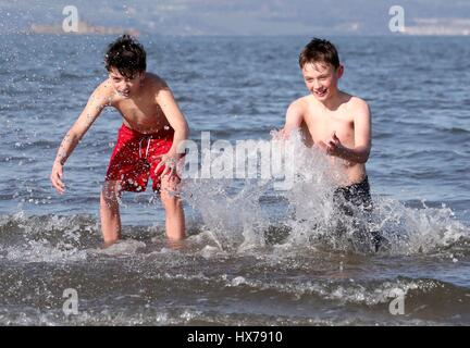 Anmerkung des Herausgebers: elterliche Erlaubnis Freunde Daryl Bothwick (links) und Kourosh Soudagar, beide im Alter von 12, nehmen Sie ein Bad im Firth of Forth Silverknowes Promenade in Edinburgh. Stockfoto