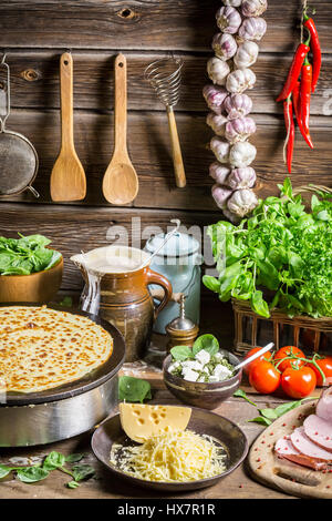 Hausgemachte Pfannkuchen mit Schinken und Käse auf alten Holztisch Stockfoto