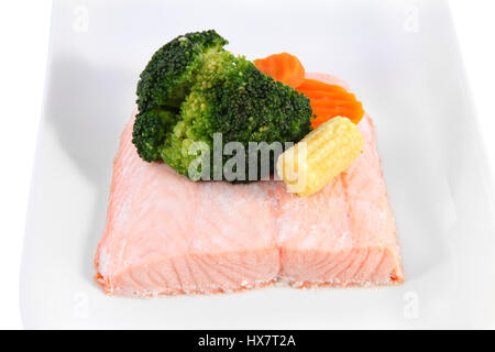 Closeup Lachsfilets auf einem Teller mit Gemüse gedünstet, marinierte junge Maiskolben Mais und Brokkoli. Stockfoto