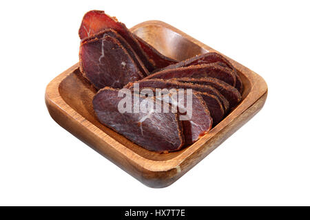 Zierliche Basturma Fleisch, getrocknete Fleisch Rinderfilet mit Gewürzen, in dünne Scheiben geschnitten, serviert in einer Holzschale isoliert auf weißem Hintergrund. Stockfoto