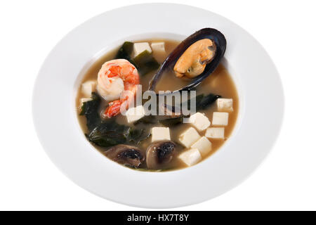 Asiatische Meeresfrüchtesuppe mit Würfel Käse Garnelen und Muscheln in der Schale, isoliert auf weißem Hintergrund. Stockfoto