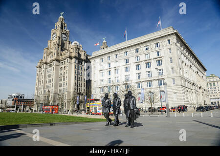 Statuen von berühmten Liverpool-Gruppe The Beatles liegt vor den berühmten Gebäuden am Molenkopf in Liverpool. Das Royal Liver Building (links) Stockfoto