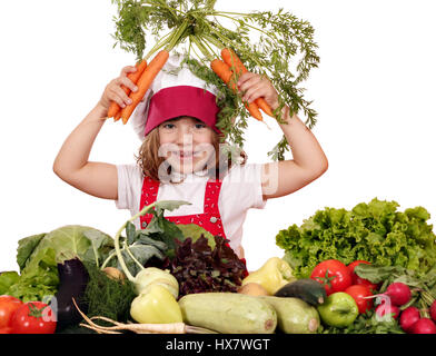 glückliches kleine Mädchen Kochen mit Karotten und Gemüse Stockfoto