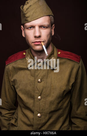 Russischer Soldat mit zweiten Weltkrieg einheitlich. Studio-Porträt auf braunem Hintergrund Stockfoto