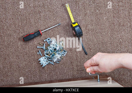 Schlüssel Möbel Schrauben, Draufsicht einer menschlichen Hand einschrauben Möbel Schrauben mit Inbus-Schlüssel. Stockfoto