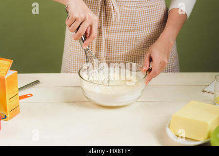 Haus Frau trägt Schürze machen. Schritte der Herstellung Kochen Schokolade Kuchen. Teig mischen Zutaten vorbereiten Stockfoto