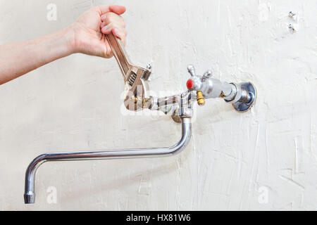 Klempner Befestigung Leitungswasser mit undichten Wasser, Nahaufnahme von Klempner Hände mit Schraubenschlüssel ein Wasserventil auf einem Rohr zu ziehen. Stockfoto