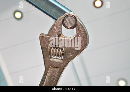 Befestigung eine Wasserhahn Belüfter, mit einem verstellbaren Schraubenschlüssel Installateur Hände Handwerker Nahaufnahme. Stockfoto