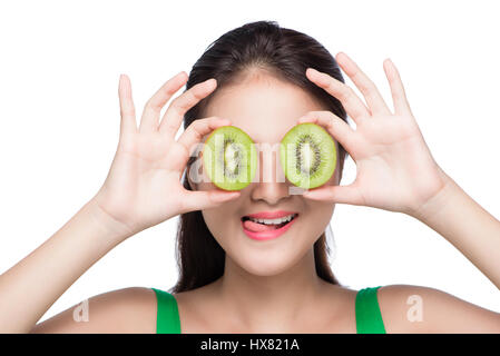 Tropische Früchte. Gesunde Ernährung. Charmante junge Asiatin halten frische saftige Kiwi und lächelt. Grünen Hintergrund. Stockfoto