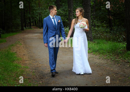Frisch verheiratetes Paar Fuß auf Parkwege Händchenhalten und sahen einander. Stockfoto