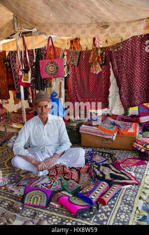 KUTCH, GUJARAT, Indien - 27. Dezember 2016: Ein nicht identifiziertes Handwerk Anbieter in seinem traditionellen Straße Laden bunte Stickereien verkaufen. Stockfoto