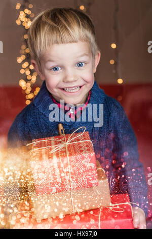 Porträt eines glücklichen kleinen Jungen hält ein neues Geschenk. Weihnachten. Geburtstag Stockfoto