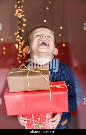 Porträt eines glücklichen kleinen Jungen hält ein neues Geschenk. Weihnachten. Geburtstag Stockfoto