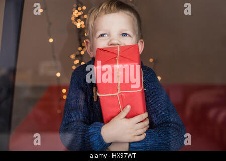 Porträt eines glücklichen kleinen Jungen hält ein neues Geschenk. Weihnachten. Geburtstag Stockfoto