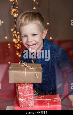 Porträt eines glücklichen kleinen Jungen hält ein neues Geschenk. Weihnachten. Geburtstag Stockfoto