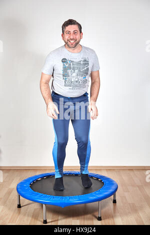Mann tut Fitness für gesunden Lebensstil auf Trampolin springen Stockfoto