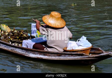 Amphawa, Thailand - 17. Dezember 2010: Frau Essen Anbieter mit Strohhut paddelt ihr Boot entlang des Kanals in Amphawa Floating Market Stockfoto