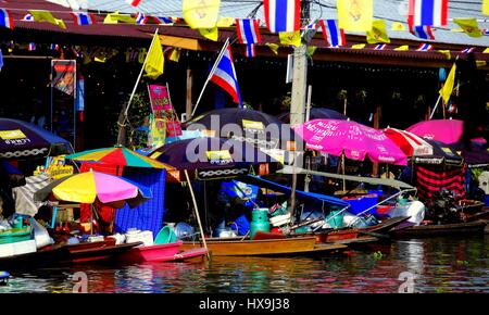 Amphawa, Thailand - 17. Dezember 2010: Bunte Sonnenschirme spenden Schatten, Imbissstände, die sitzen in ihren angedockten Booten an der Amphawa schwimmenden Markt Stockfoto