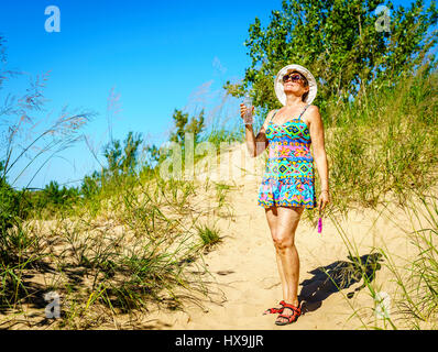 Glückliche Frau mit Wasserflasche auf einem Pfad durch Sleeping Bear Dünen in Nord-Michigan Stockfoto