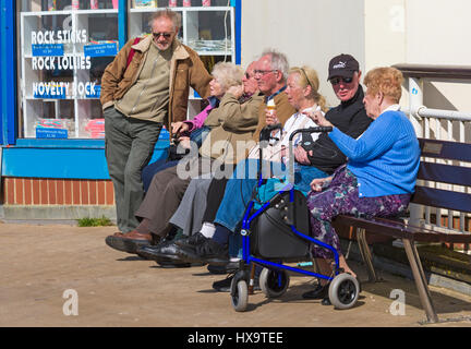 Bournemouth, Dorset, UK. 26. März 2017. UK-Wetter: schönen warmen, sonnigen Tag als Besucher gehen ans Meer machen das Beste aus der Sonne an den Stränden von Bournemouth. Gruppe von Senioren sitzen außerhalb der Rock Shop am Eingang zum Bournemouth Pier genießen den Sonnenschein Credit: Carolyn Jenkins/Alamy Live News Stockfoto