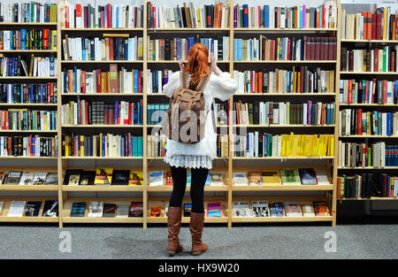 Leipzig, Deutschland. 26. März 2017. Ein Besucher stehend auf einem Bücherregal mit Antiquar Bücher auf der Leipziger Buchmesse in Leipzig, Deutschland, 26. März 2017. Heute die Messe endet, mit rund 2400 Aussteller präsentierte ihre neue Veröffentlichungen aus dem Buch und publishing-Branche. Foto: Jens Kalaene/Dpa-Zentralbild/ZB/Dpa/Alamy Live News Stockfoto