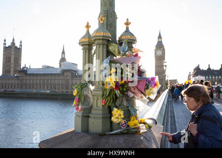 London, UK. 25. März 2017. Fußgänger untersuchen Frühlingsblumen und Nachrichten auf Westminster Bridge in Gedenken an die Opfer von Terror-Anschlag auf Westminster am 22. März angeordnet. Bildnachweis: Mark Kerrison/Alamy Live-Nachrichten Stockfoto