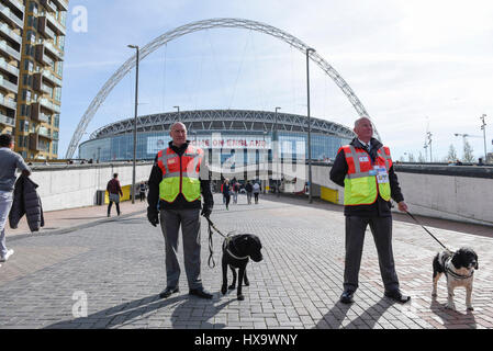 London, UK.  26. März 2017.  Handler mit Polizeihunde, die tragen Jacken Explosive Suche gekennzeichnet sind auf Wembley Weg gesehen. Nach dem Terroranschlag von Westminster ist eine sichtbare Präsenz auf dem Display außerhalb Wembley-Stadion für WM-Qualifikation-Spiel zwischen England und Litauen.   Bildnachweis: Stephen Chung / Alamy Live News Stockfoto