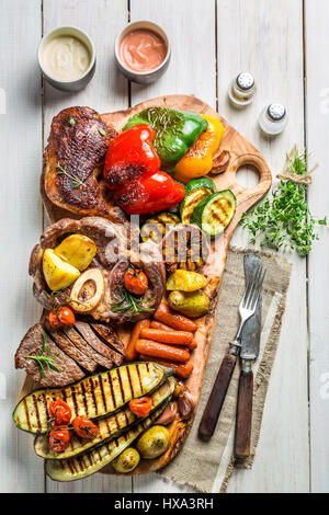 Gegrilltem Gemüse und Steak mit Salz auf Holzbrett Stockfoto