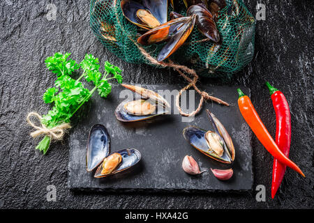 Nahaufnahme von fangfrischen Muscheln auf schwarzen Felsen Stockfoto