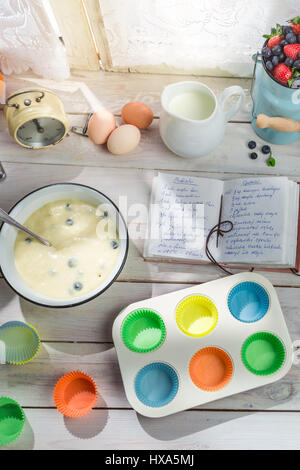 Backen leckere Muffins mit Heidelbeeren auf alten weißen Tisch Stockfoto
