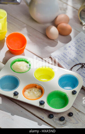 Vorbereitung für leckere Muffins mit Heidelbeeren auf alten weißen Tisch Stockfoto